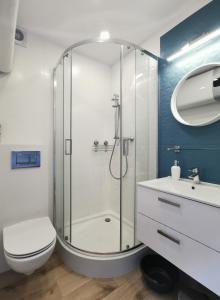 a bathroom with a shower and a toilet and a sink at Apartament La Playa in Rowy