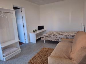 een woonkamer met een bed en een bank bij Arrivillage in Arrifes