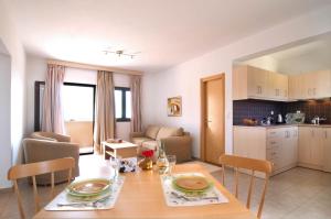 a kitchen and living room with a table and chairs at Miraluna Aparthotel in Lefkos Karpathou