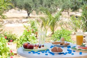 a table topped with plates of food and drinks at Miraluna Aparthotel in Lefkos Karpathou