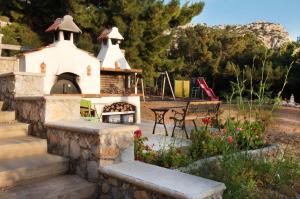 a backyard with a fireplace and a playground at Miraluna Aparthotel in Lefkos Karpathou