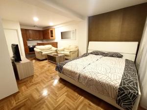 ein Schlafzimmer mit einem Bett und ein Wohnzimmer in der Unterkunft Apartman City Center 1-šetalište in Prijedor