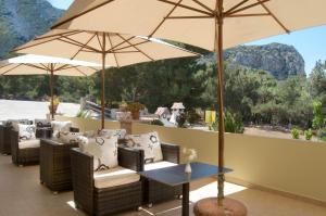 a patio with chairs and tables with umbrellas at Miraluna Aparthotel in Lefkos Karpathou