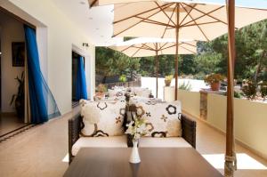 a dining room with a table and umbrella at Miraluna Aparthotel in Lefkos Karpathou