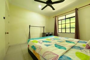 um quarto com uma cama e uma ventoinha de tecto em OYO Home 90318 Tambunan Nature Lodge em Tambunan