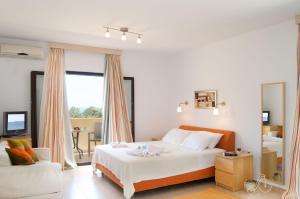 a bedroom with a large white bed and a couch at Miraluna Aparthotel in Lefkos Karpathou