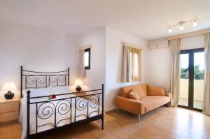a bedroom with a bed and a chair in a room at Miraluna Aparthotel in Lefkos Karpathou