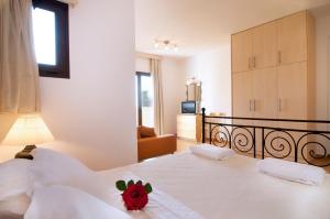 a bedroom with a bed with a red stuffed animal on it at Miraluna Aparthotel in Lefkos Karpathou