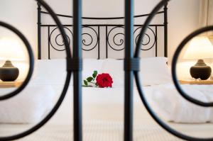 a red rose on a bed with white pillows at Miraluna Aparthotel in Lefkos Karpathou