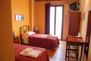 una camera d'albergo con due letti e una finestra di Agriturismo Ai Due Volti a Dossobuono