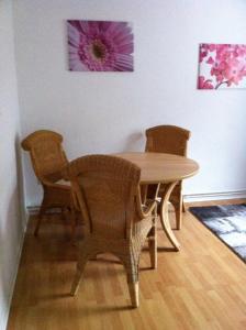 een eettafel met twee stoelen en een tafel en een tafel en een stoeltje bij Haus Weiche in Flensburg