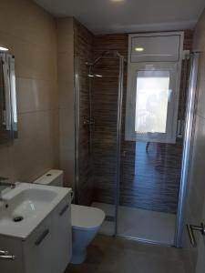 a bathroom with a shower and a toilet and a sink at Apartamentos Dins Mar Apto. 1 in Torredembarra