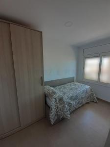 sypialnia z łóżkiem i przesuwnymi drzwiami w obiekcie Apartamentos Dins Mar Apto. 1 w mieście Torredembarra