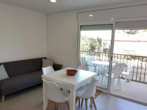 un soggiorno con divano, tavolo e sedie di Apartamentos Dins Mar Apto. 1 a Torredembarra