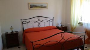 a bedroom with a bed with an orange blanket at Villa Carmelas in Taormina