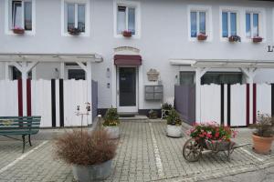 una casa blanca con macetas delante de ella en L'Union B&B - Chambres d'hôtes, en Tramelan