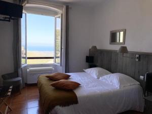 a bedroom with a large bed with a large window at U Sant'Agnellu in Rogliano