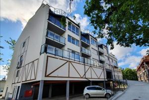 a white building with a car parked in front of it at Apartament La Playa in Rowy