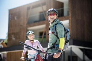 a man and a woman on a bike at Aparthotel Gamz in Sesto