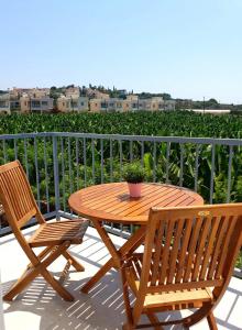 - Balcón con mesa de madera y 2 sillas en Blue Seaview Appartments en Pafos
