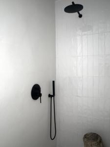 - Baño con ducha y sombrero en la pared en ESTUDIO BEDANDBEACH, en El Palmar