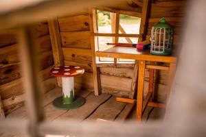 an inside view of a wooden cabin with a stool and a table at Hiiemäe Puhkemaja in Kunda