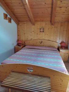 1 dormitorio con 1 cama en una habitación de madera en La casa di Grace nella valle incantantata, en Carano
