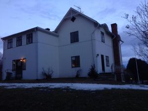 a large white house with a chimney on top at Vindsvåning Höga Kusten in Kramfors