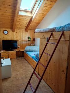 a room with two bunk beds and a television at La casa di Grace nella valle incantantata in Carano