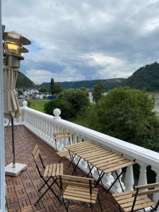 a balcony with a table and chairs and a view of a river at Paradiesisch Wohnen - Loreley in Sankt Goarshausen