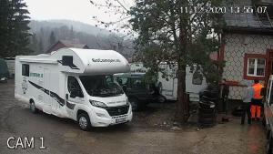 a white camper truck parked next to a house at Camping Aviator Busteni, Parcare rulota termen lung (6-12 luni). in Buşteni