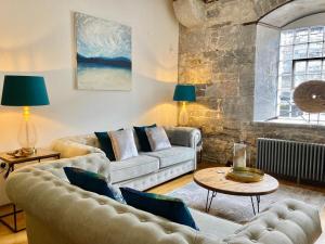 a living room with two couches and a table at Luxurious "THE BRUCE" - - Offering EITHER a LARGE FAMILY APARTMENT and OR a DELUXE STUDIO ROOM That CONNECT IN PRIVATE LOBBY - BOOK BOTH IF REQUIRED - So Beautifully Refurbished - - with FREE Onsite PARKING in Plymouth