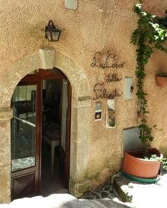 une entrée à un bâtiment avec un panneau sur celui-ci dans l'établissement La Casa della Filanda, à Belmonte Calabro