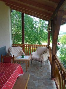 un porche cubierto con mesa y sillas en Seosko domacinstvo Lelic Ristivojevic, en Valjevo