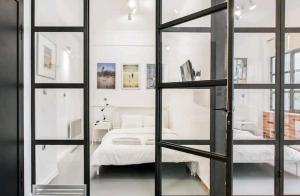 Habitación con puerta de cristal y cama. en Fashionable Base in Central Athens in the Old Tailor Factory en Athens