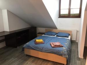 a bedroom with a bed with two towels on it at Apartament Metamorfoza in Nowy Targ