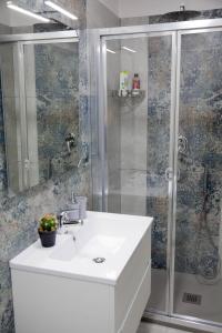 W łazience znajduje się biała umywalka i prysznic. w obiekcie Plebiscito House - Casa Vacanze Napoli w mieście Neapol