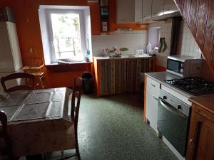 a kitchen with a stove and a table and a window at Gite familial à proximité d'une mini ferme in Saint-Haon