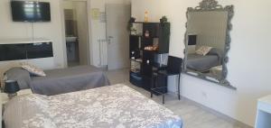 een woonkamer met een bed en een spiegel bij alhena room in Terracina