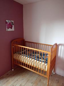 a nursery with a crib in a room at Gite familial à proximité d'une mini ferme in Saint-Haon