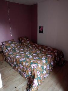 1 cama en un dormitorio con un edredón colorido en Gite familial à proximité d'une mini ferme en Saint-Haon