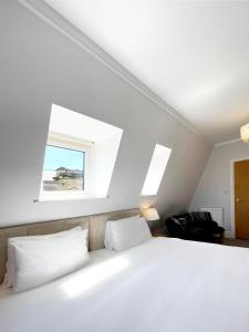 a bedroom with a white bed with two pillows at Dukes Folly Hotel in Southport