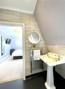 a bathroom with a sink and a mirror and a bed at Dukes Folly Hotel in Southport