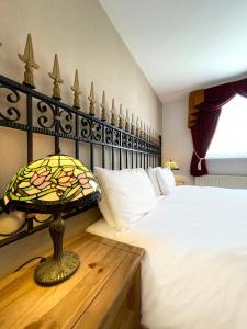 a bedroom with a bed and a table with a lamp at Dukes Folly Hotel in Southport
