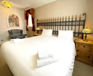 a bedroom with a large white bed and a chair at Dukes Folly Hotel in Southport