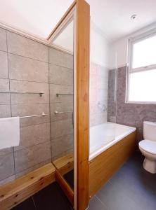 a bathroom with a bath tub and a toilet at Dukes Folly Hotel in Southport