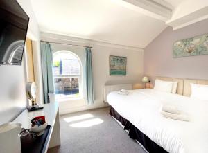 a bedroom with two beds and a window at Dukes Folly Hotel in Southport