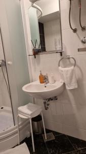 ein Bad mit einem Waschbecken und einer Dusche mit einem Spiegel in der Unterkunft Star of stone in Jelsa