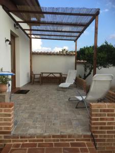 d'une terrasse avec 2 chaises blanches et une table. dans l'établissement Agriturismo Le Terre Di Zoe', à Limbadi