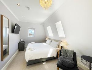 a bedroom with a white bed and a chair at Dukes Folly Hotel in Southport